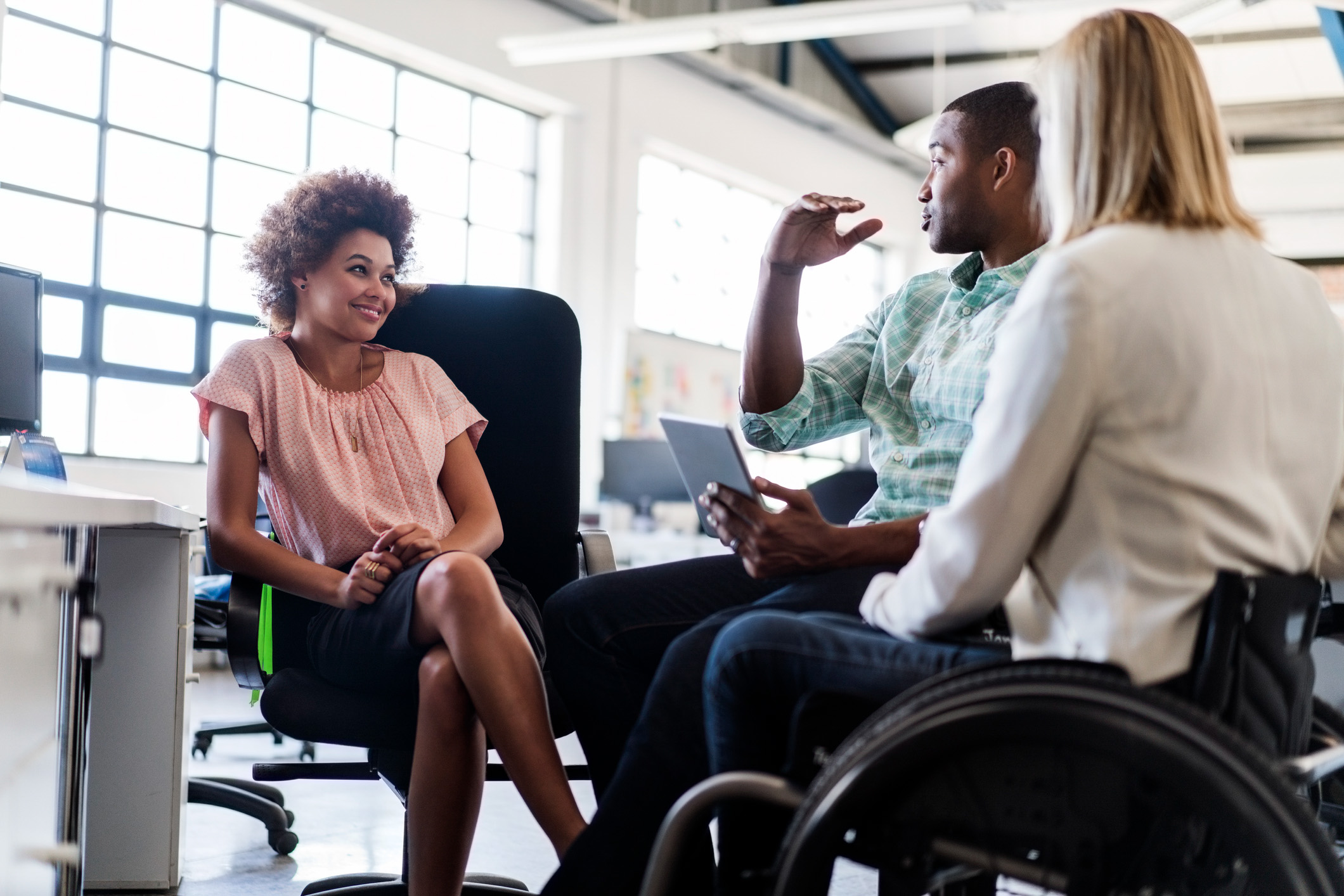 woman talking with disabled workers about their options, smiling