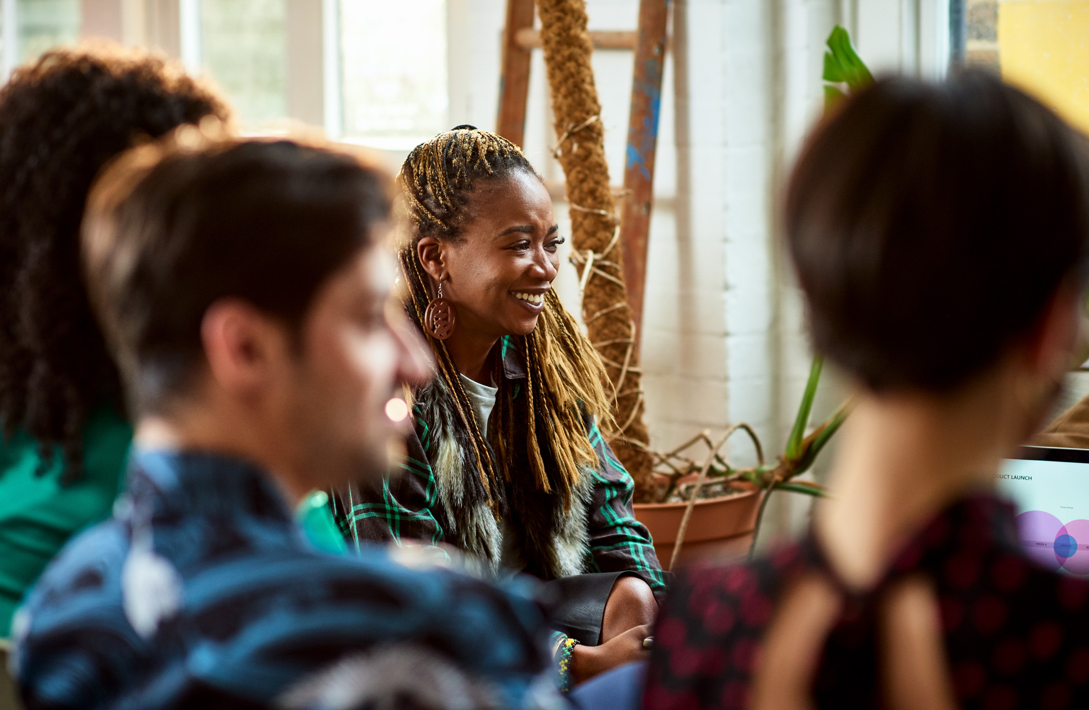 Cheerful mid adult woman working in team meeting, start up, optimism, inclusion